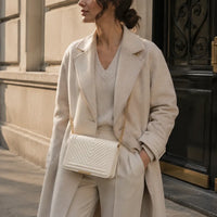 Petit sac bandoulière Anaëlle Blanc cassé porté dans une rue parisienne