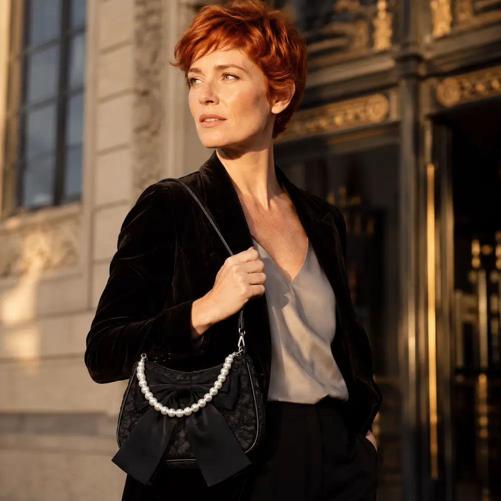 Sac à main perlé Célestine noir porté en lifestyle à Paris