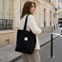 Sac cabas Mélina Noir porté dans une rue parisienne