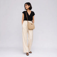 Sac bandoulière en paille Ondine beige porté en studio plein pied