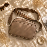 Petit sac à main marron Hermine, flatlay premium sur satin champagne