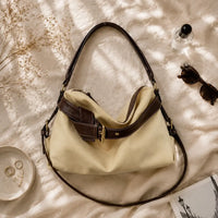Sac à main beige Bertille, flatlay premium sur satin champagne