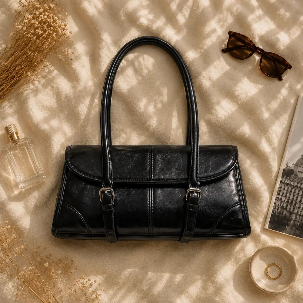 Sac à main noir Nine, flatlay premium sur satin champagne