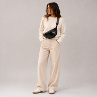 Sac banane femme avec chaîne noir porté – studio plein pied